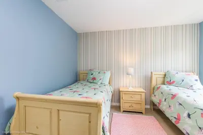 a bedroom with two twin beds and a night stand at 2739SKP New Emerald Island 4 Bedroom townhouse in Kissimmee