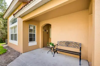 a bench sitting outside of a house at 2739SKP New Emerald Island 4 Bedroom townhouse in Kissimmee