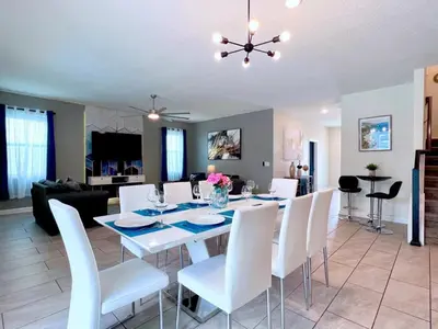 a dining room and living room with a table and chairs at Eight-Bedroom House in Kissimmee
