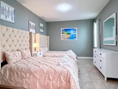 a bedroom with a pink bed and a white dresser at Eight-Bedroom House in Kissimmee