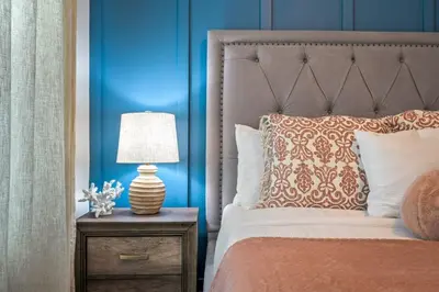 a bedroom with a bed and a lamp on a nightstand at Brand New Corner Lot Pond View Vacation Home in Kissimmee