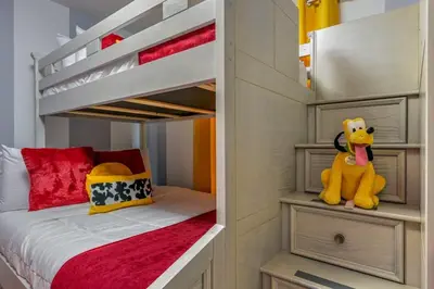 a small bedroom with a bunk bed with a yellow stuffed animal at Brand New Corner Lot Pond View Vacation Home in Kissimmee
