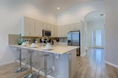 a kitchen with a island in the middle of a room at #372-Welcome to Lightwater Villa, your Modern Disney Vacation home! South-Facing Pool & Spa Overlooking Lake in Kissimmee