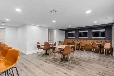 a waiting room with tables and chairs in a building at Travelodge by Wyndham Kissimmee Orlando in Kissimmee