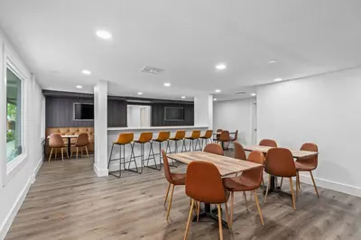 a dining room with tables and chairs and a bar at Travelodge by Wyndham Kissimmee Orlando in Kissimmee