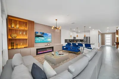 a living room with a large couch and a kitchen at 9 Bed Pool Home Storey Lake Resort! home in Kissimmee