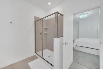 a glass shower in a white room with a bed at 9 Bed Pool Home Storey Lake Resort! home in Kissimmee