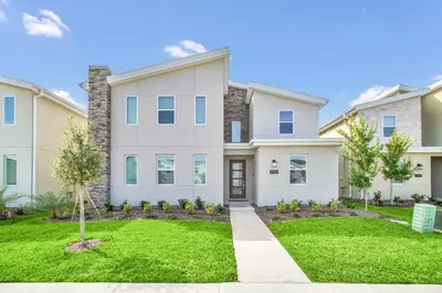 a large white house with a green lawn at 9 Bed Pool Home Storey Lake Resort! home in Kissimmee