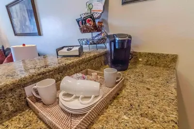 a counter with cups and plates and a coffee maker at Spacious 4 bed 3 bath Townhome with pool 5 STARS!! in Kissimmee
