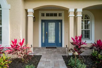 a blue front door of a house with pink plants at Luxury Villa! Fun in the Sun! Formosa Gardens in Orlando