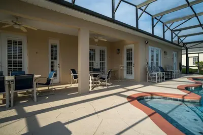 a patio with a swimming pool and chairs and a house at Luxury Villa! Fun in the Sun! Formosa Gardens in Orlando
