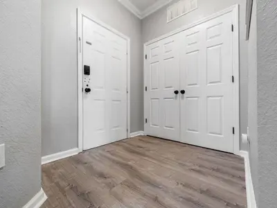 an empty room with two white doors and wood floors at Mickey's Hideaway Windsor Hills Resort in Orlando