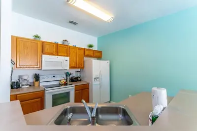 a kitchen with a sink and a white refrigerator at 4552 Bella Vida 2 in Kissimmee