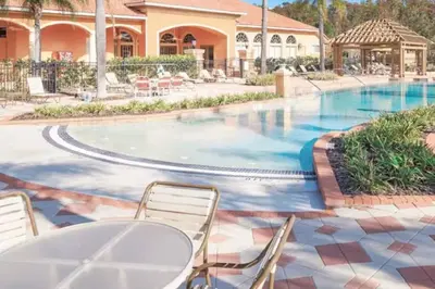 a pool at a resort with chairs and tables at 4552 Bella Vida 2 in Kissimmee