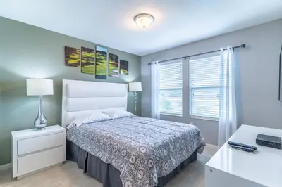 a bedroom with a bed and a desk and a window at 5134 Compass Bay in Kissimmee