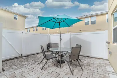 a patio with a table and chairs and an umbrella at 5134 Compass Bay in Kissimmee