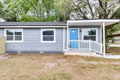 a small house with a blue door in a yard at Dtwn Winter Garden Home 12 Mi to Disney! in Orlando