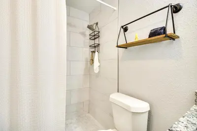 a white bathroom with a toilet and a shower at Dtwn Winter Garden Home 12 Mi to Disney! in Orlando