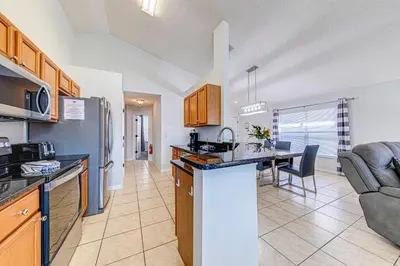 a kitchen and living room with a table in it at #463-Fabulous 4 bed villa with south facing private pool and spa overlooking water in Kissimmee
