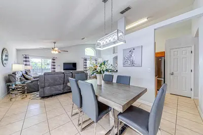 a dining room and living room with a table and chairs at #463-Fabulous 4 bed villa with south facing private pool and spa overlooking water in Kissimmee