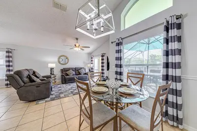a dining room and living room with a table and chairs at #463-Fabulous 4 bed villa with south facing private pool and spa overlooking water in Kissimmee