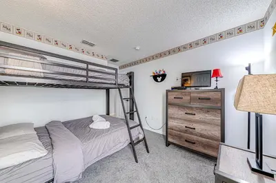 a bedroom with a bunk bed and a television at #463-Fabulous 4 bed villa with south facing private pool and spa overlooking water in Kissimmee