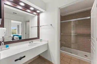 a bathroom with a sink and a mirror and a shower at 1BR FREE Shuttle to Disney Parks HS305 in Orlando