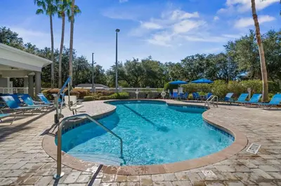 a swimming pool with blue lounge chairs and a resort at 1BR FREE Shuttle to Disney Parks HS305 in Orlando