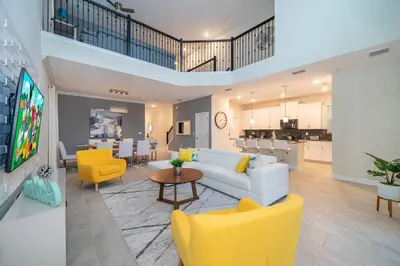 a living room with a white couch and yellow chairs at Fabulous Villas 5 minutes away from Disney! in Kissimmee