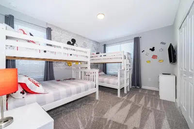 a bedroom with two bunk beds and a desk at Fabulous Villas 5 minutes away from Disney! in Kissimmee