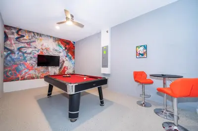 a room with a pool table and two chairs at Fabulous Villas 5 minutes away from Disney! in Kissimmee
