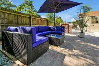 a purple couch and an umbrella on a patio at Private Villa/Outdoor Oasis in Kissimmee
