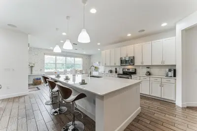 a kitchen with white cabinets and a large island with bar stools at 65 Home At Sonoma Resort, Private Pool, And Much More!! in Kissimmee
