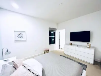 a white bedroom with a bed and a flat screen tv at 65 Home At Sonoma Resort, Private Pool, And Much More!! in Kissimmee