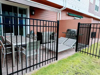 a fence with a table and chairs and a grill at Gorgeous New 4 Beds DREAM Villa 5 min to Disney in Orlando