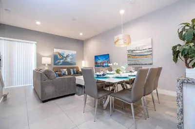 a dining room with a table and a couch at Gorgeous NEW 4 Beds Dream Villa 5 min to Disney in Orlando