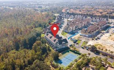 an aerial view of a house with a tennis court and a red marker at Dreamscape NEW 4 Suites Villa 5 min to Disney in Orlando