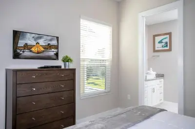 a bedroom with a dresser and a window at Dreamscape NEW 4 Suites Villa 5 min to Disney in Orlando