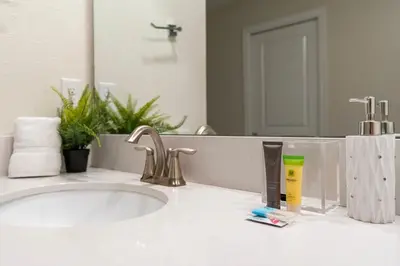 a bathroom counter with a sink and a mirror at New Home 9Bedrooms e 5Bath At Storey Lake in Kissimmee