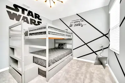 a room with bunk beds with a star wars sign on the wall at 10BR Resort Home - Pool Hot tub Games - Near Disney in Kissimmee