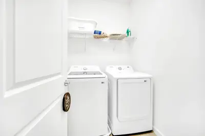 a white laundry room with a washer and dryer at 10BR Resort Home - Pool Hot tub Games - Near Disney in Kissimmee