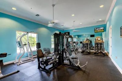 a gym with several tread machines in a room at 10BR Resort Home - Pool Hot tub Games - Near Disney in Kissimmee