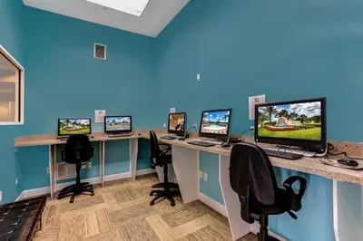 an office with four computer desks with computers on them at 10BR Resort Home - Pool Hot tub Games - Near Disney in Kissimmee