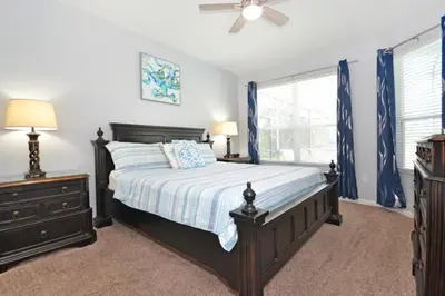 a bedroom with a bed and a dresser and a window at Under The Sea Villa villa in Orlando