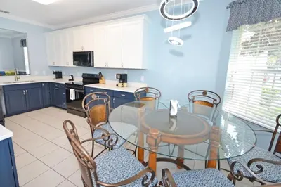 a kitchen with a glass table and chairs at Under The Sea Villa villa in Orlando