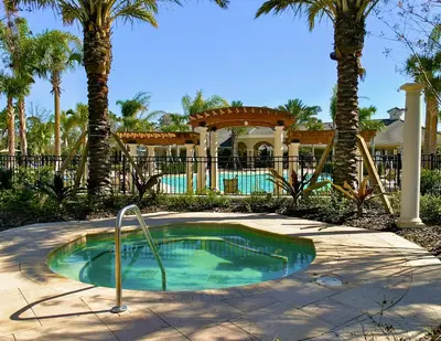 a small swimming pool in a yard with palm trees at Incredible Condo - 5 Min to Disney Windsor Hills in Orlando