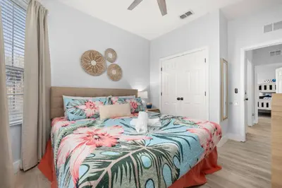 a bedroom with a large bed with a floral bedspread at Windsor Hills Dream - 3BR - 2 miles from Disney in Orlando