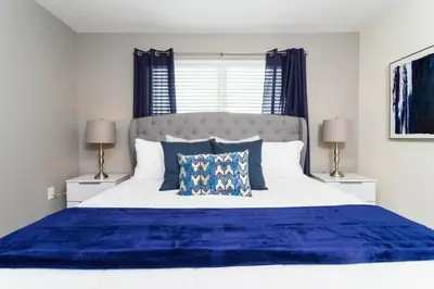 a bedroom with a large blue bed with two lamps at Amazing Villa 5BR Heated Pool Themed Rooms - 5 miles Disney in Kissimmee
