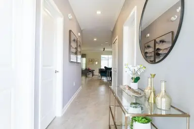a hallway with a mirror and a table with vases at Amazing Villa 5BR Heated Pool Themed Rooms - 5 miles Disney in Kissimmee