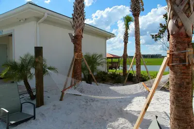a hammock in front of a house with palm trees at Lake View - 10 min to Disney Storey Lake Resort in Kissimmee